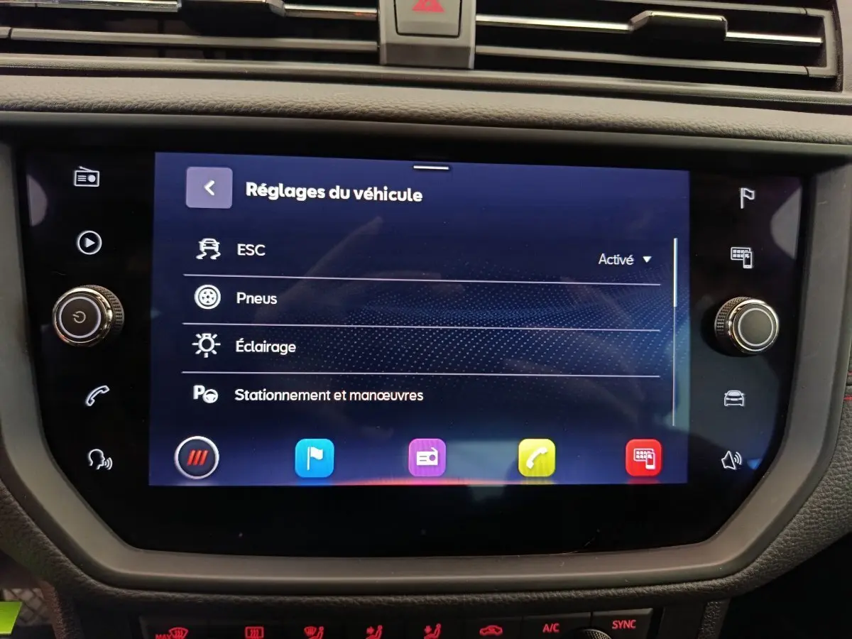 Écran tactile central du tableau de bord du SEAT Arona bleu 2021 affichant les réglages du véhicule.