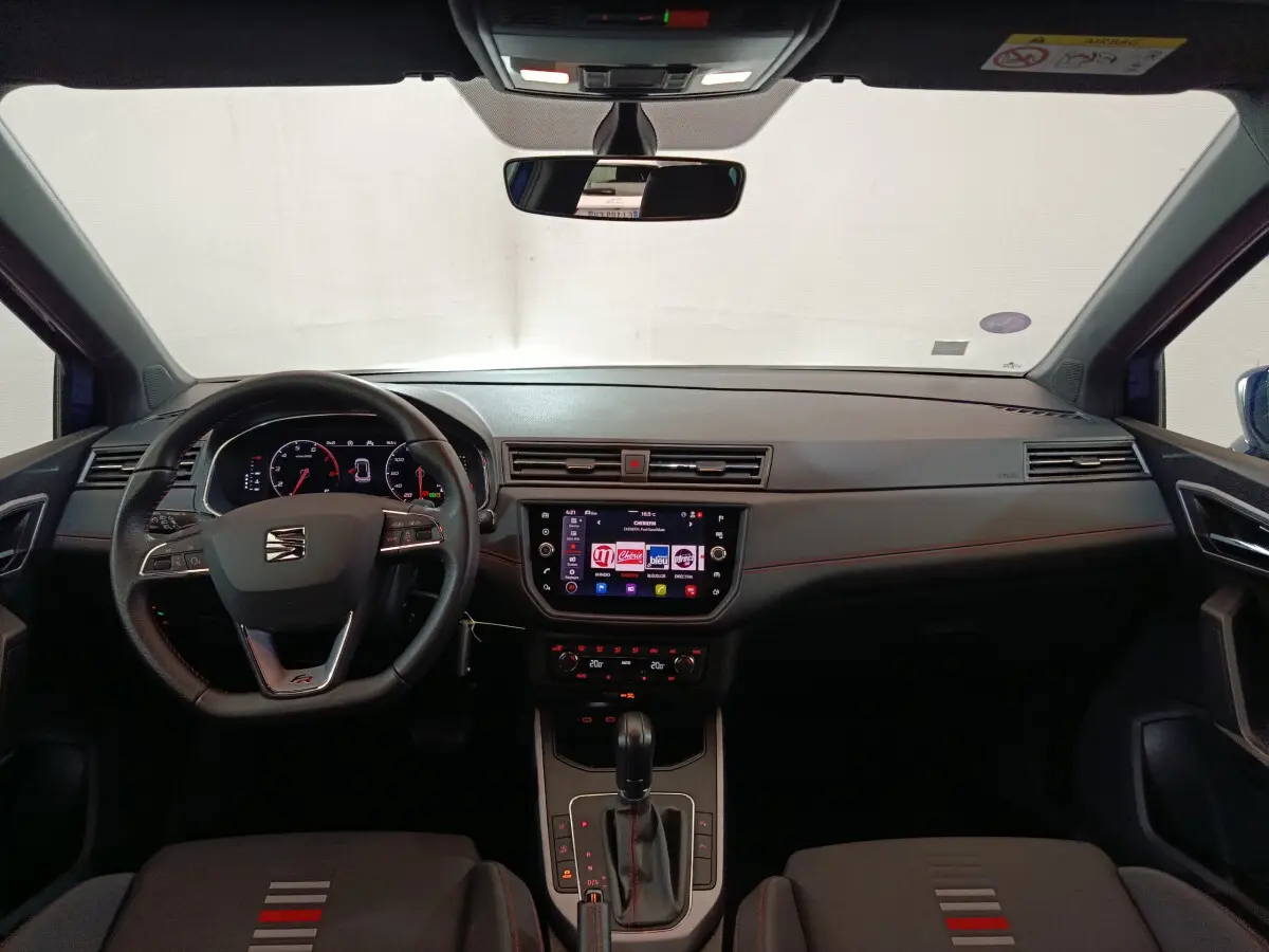 Intérieur du SEAT Arona bleu 2021, vue frontale du tableau de bord avec écran tactile et volant multifonctions.