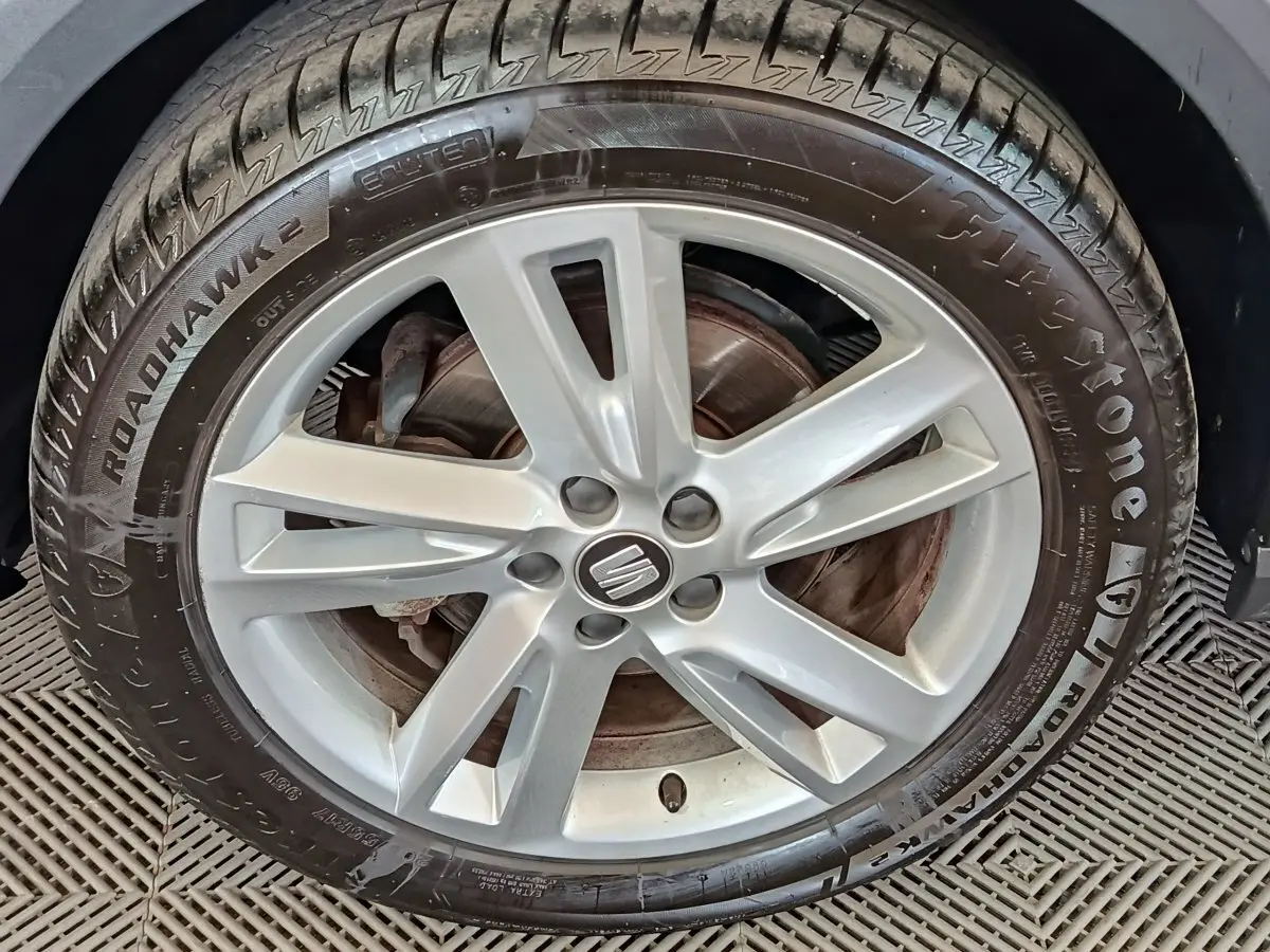 Gros plan sur la jante argentée d'une SEAT ARONA 2021 avec pneu Firestone Roadhawk 2 visible.