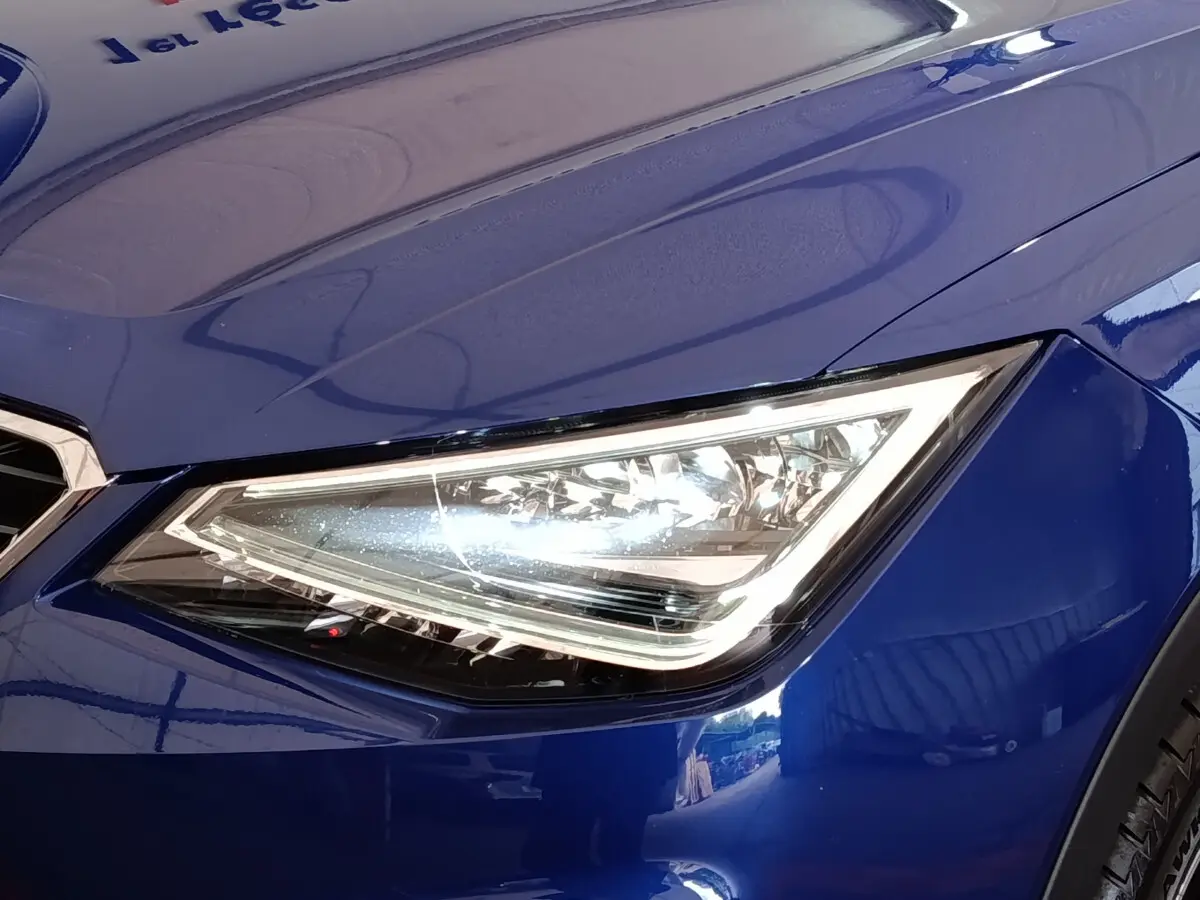 Gros plan sur le phare avant droit LED d'une SEAT ARONA bleu 2021, soulignant son design anguleux moderne.