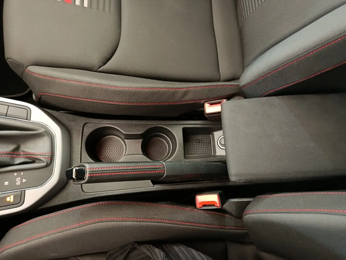 Vue plongeante sur la console centrale noire avec surpiqûres rouges du SEAT Arona 2021 finition FR.