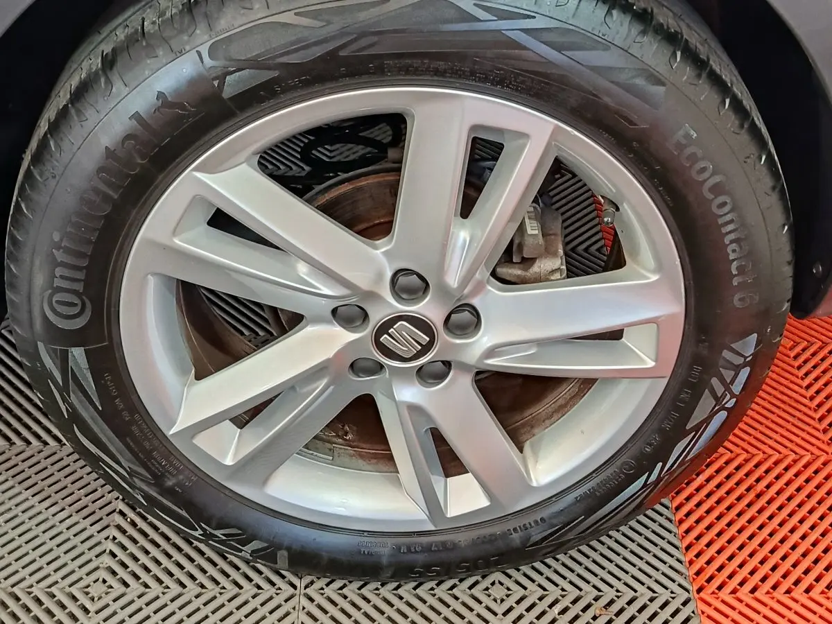 Gros plan sur la jante alliage argentée avec logo SEAT d’un pneu Continental monté sur un SEAT Arona bleu.