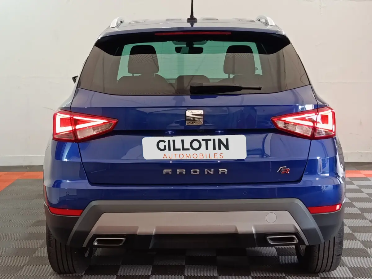 Vue arrière d'un SEAT Arona bleu 2021 finition FR avec feux LED et double sortie d'échappement intégrée.