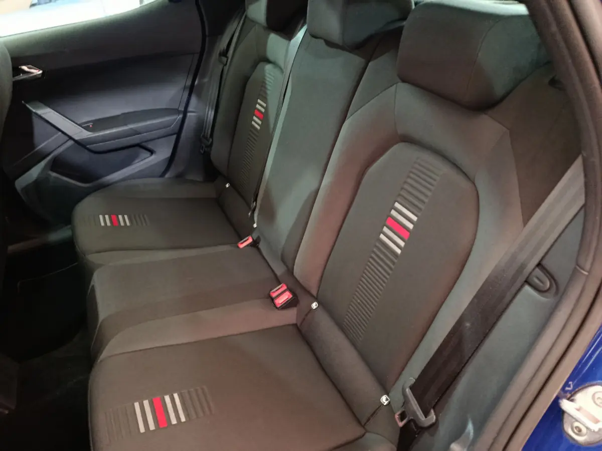 Vue intérieure de la banquette arrière noire avec motifs rouges et grisés du SEAT Arona bleu 2021 côté droit.