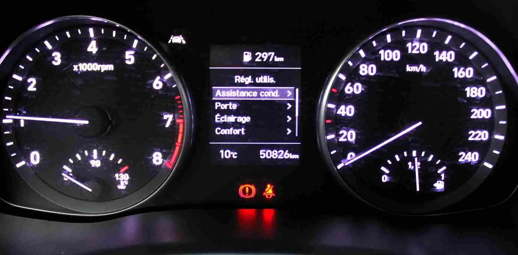 Tableau de bord éclairé de la Hyundai i30 SW blanche, affichant compte-tours, vitesse, température et menu d'assistance conducteur.