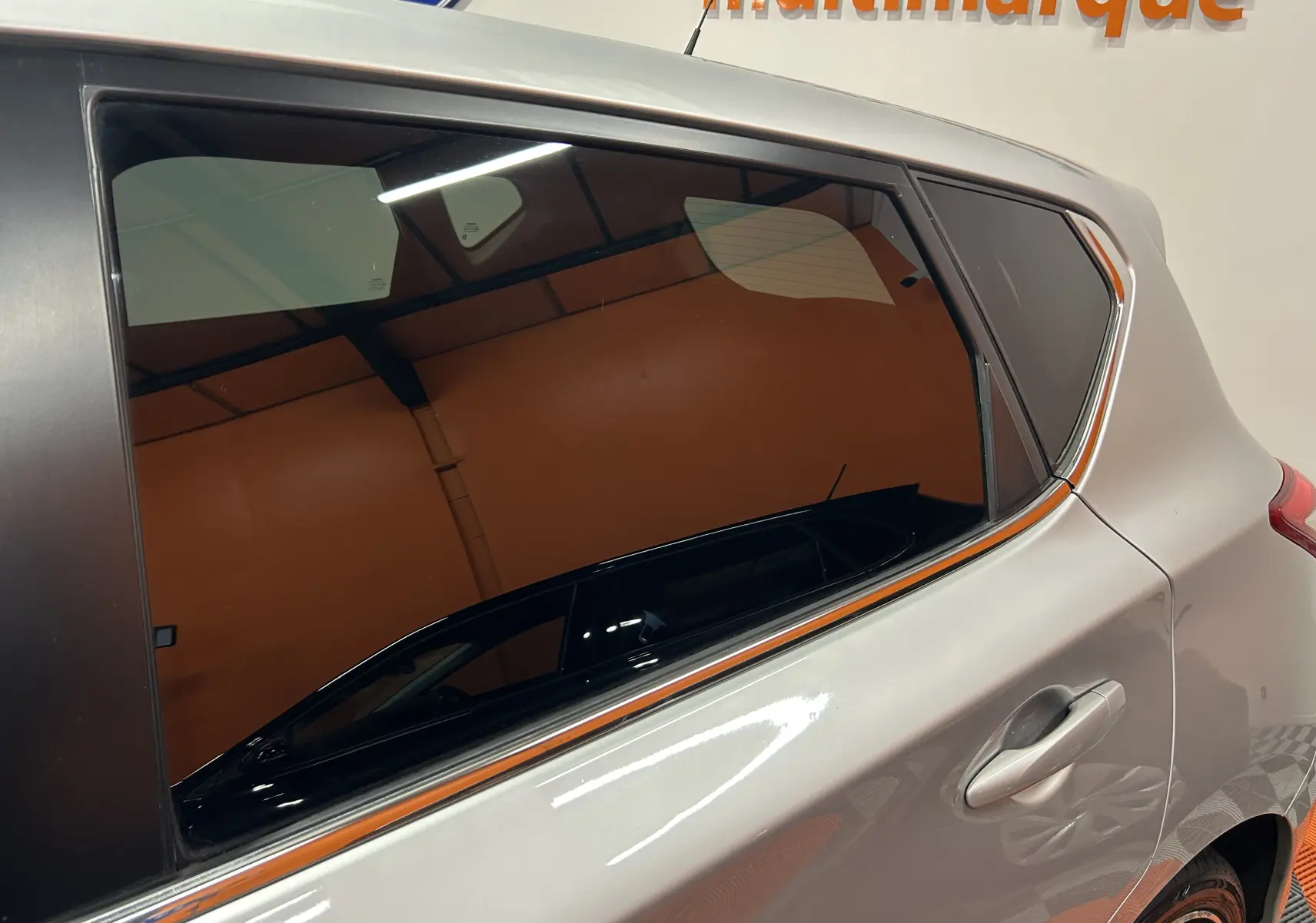 Gros plan sur la porte arrière droite gris métallisé d’une Nissan Pulsar 2018 avec vitre teintée et poignée intégrée.