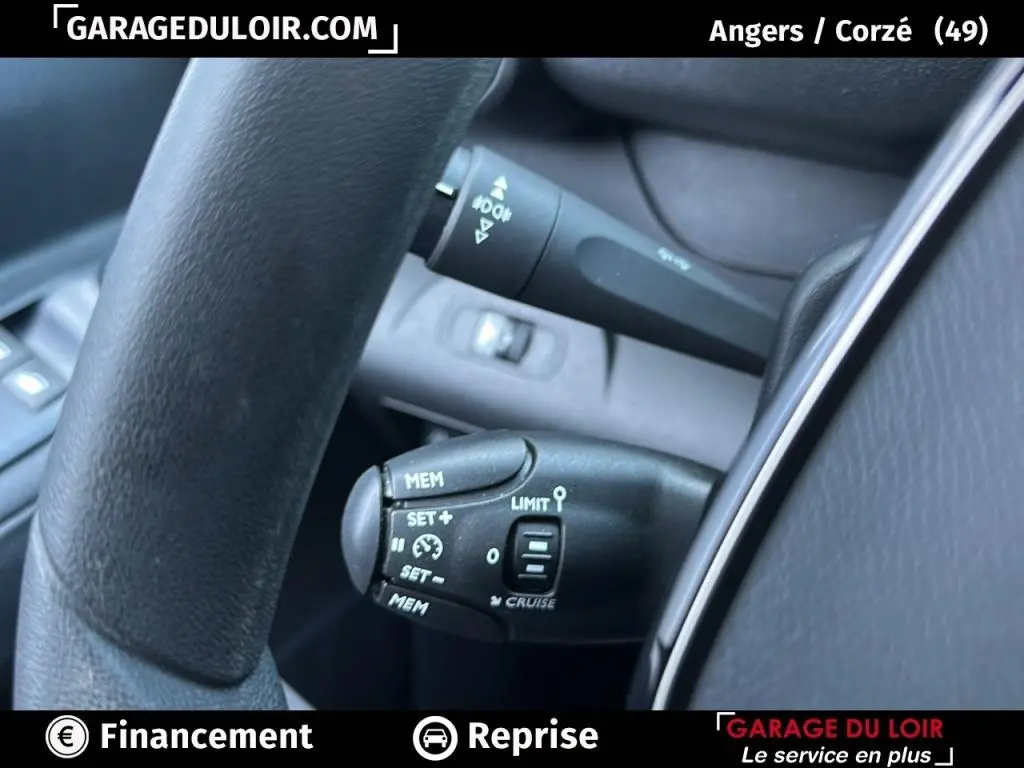 Gros plan sur les commandes au volant du Peugeot Rifter 2024 bleu, mettant en valeur le régulateur de vitesse et les commandes limitateur.