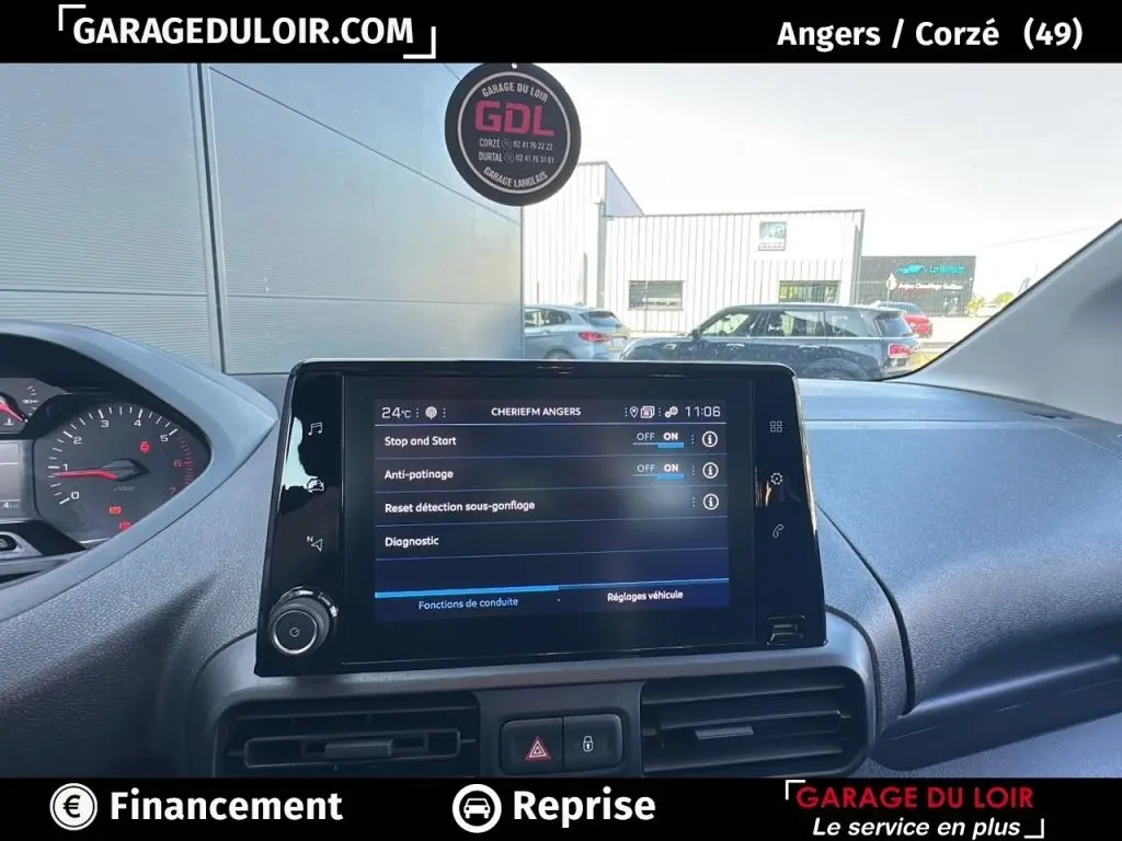 Vue intérieure centrée sur l'écran tactile du tableau de bord du Peugeot Rifter bleu 2024, affichant les réglages du véhicule.