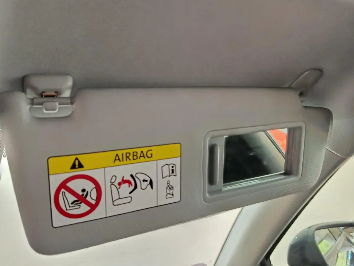 Détail du pare-soleil côté conducteur avec miroir intégré et avertissement airbag dans l’Audi Q2 gris foncé.