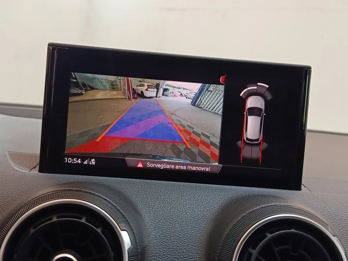Écran tactile intérieur montrant la caméra de recul et l'aide au stationnement de l'Audi Q2 35 TFSI gris foncé.