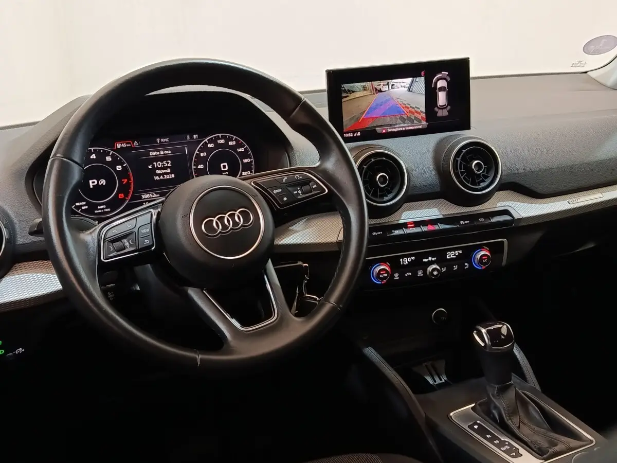 Vue intérieure de l'Audi Q2 35 TFSI 2022 montrant le volant cuir, tableau de bord digital et écran tactile central.