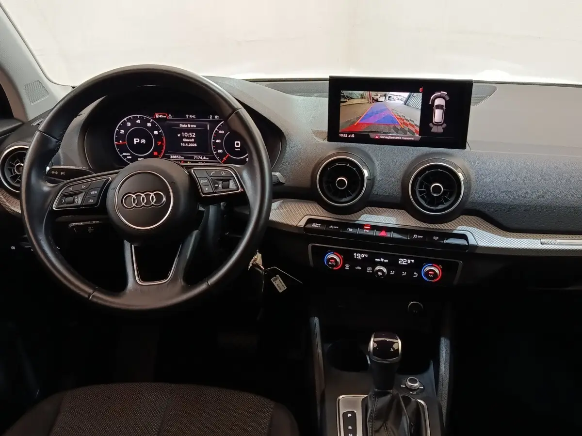 Vue intérieure de l'Audi Q2 35 TFSI 2022, tableau de bord avec écran tactile et volant cuir multifonctions noir.