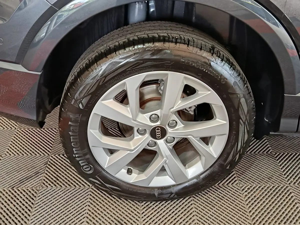 Gros plan sur la roue avant droite d’un Audi Q2 gris foncé, avec jante en alliage et pneu Continental.
