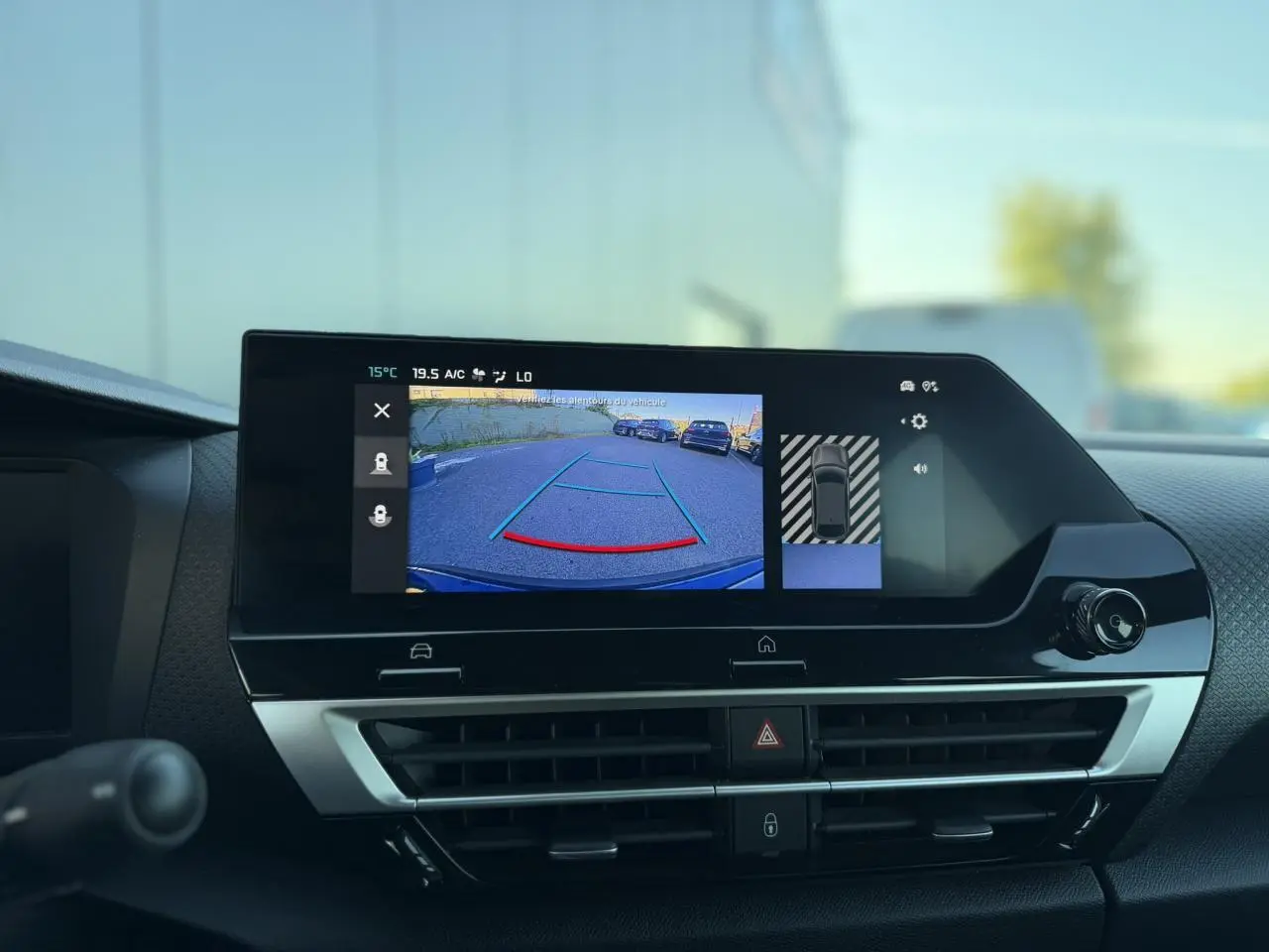 Vue intérieure du tableau de bord de la Citroën C4 Hybrid 145, écran tactile affichant la caméra de recul et la navigation.