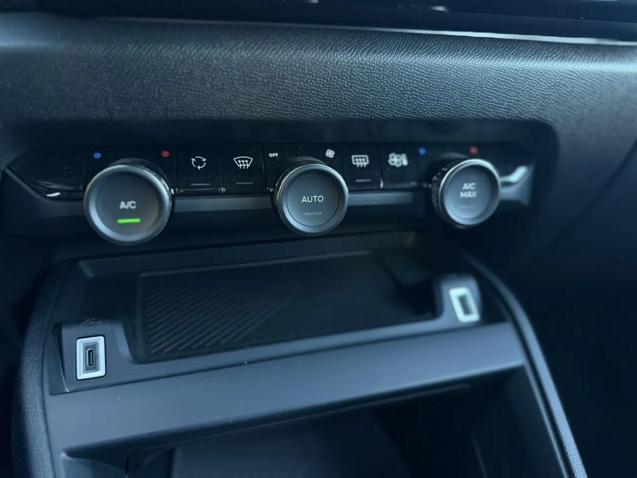 Gros plan sur la console centrale de la Citroën C4 Hybrid 145 e-DSC6 Plus, montrant les commandes de climatisation automatique.