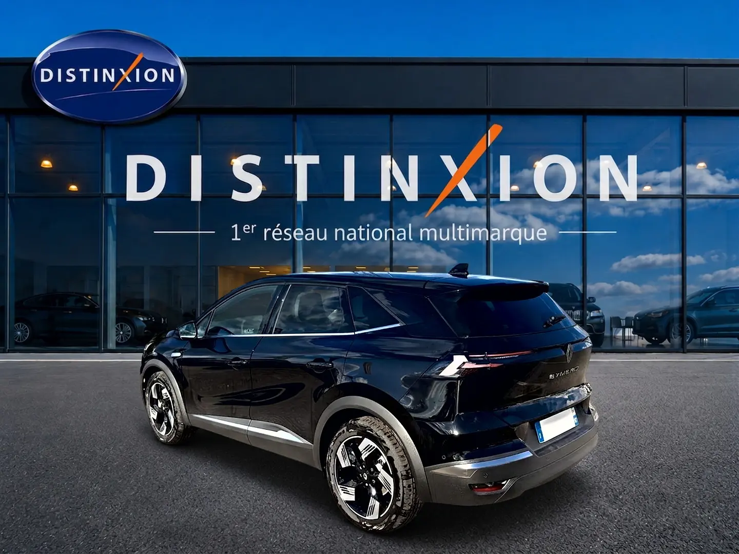 Vue 3/4 arrière droite d'un Renault Symbioz noir étoile avec jantes alu, garé devant une vitrine Distinxion.