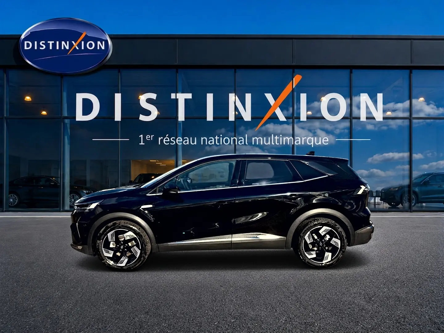 Profil droit d'un Renault Symbioz 2026 noir étoile, avec jantes alu distinctives, devant une vitrine Distinxion.