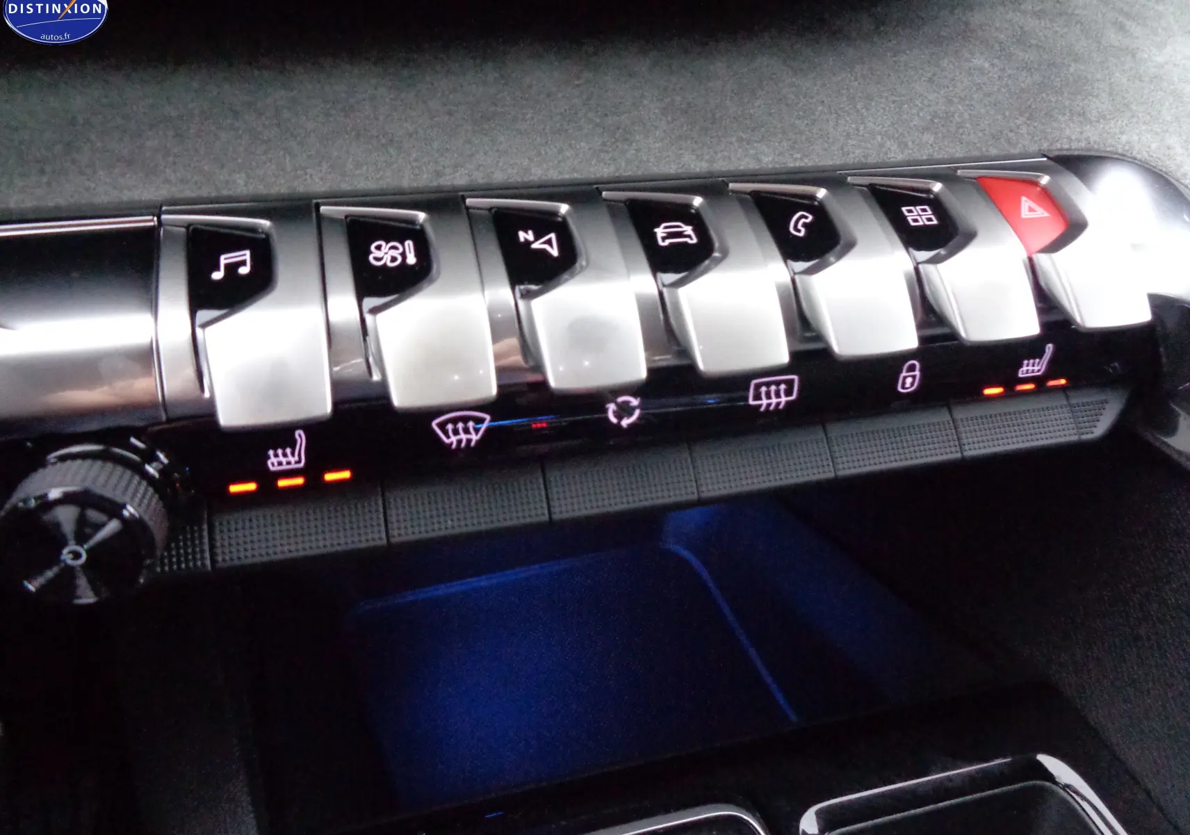 Gros plan sur les commandes piano du tableau de bord du Peugeot 3008 gris platinium, avec éclairage rouge des sièges chauffants.