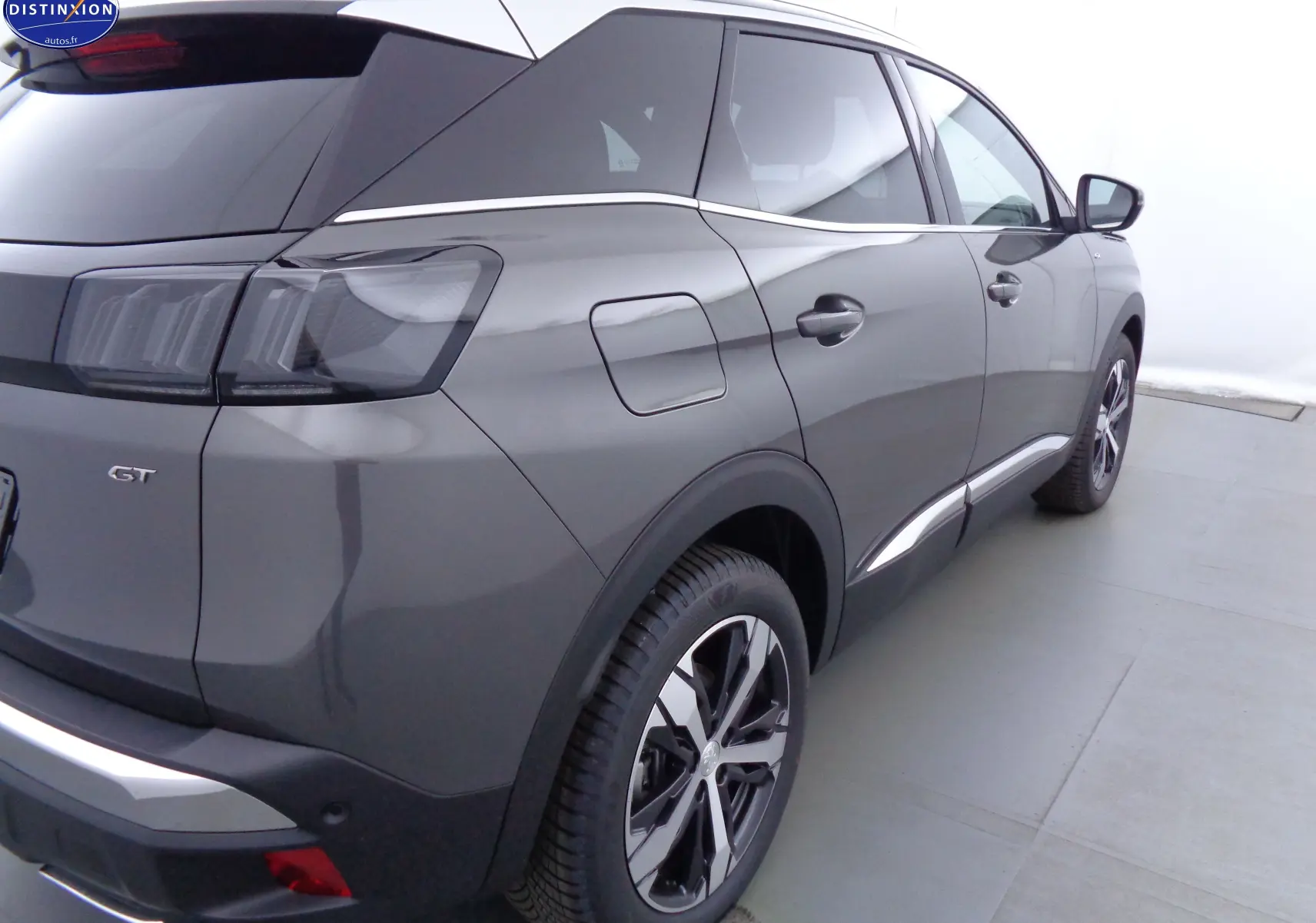 Vue 3/4 arrière droit du Peugeot 3008 GT gris platinium métallisé avec feux arrière LED et jantes alliage bicolores.