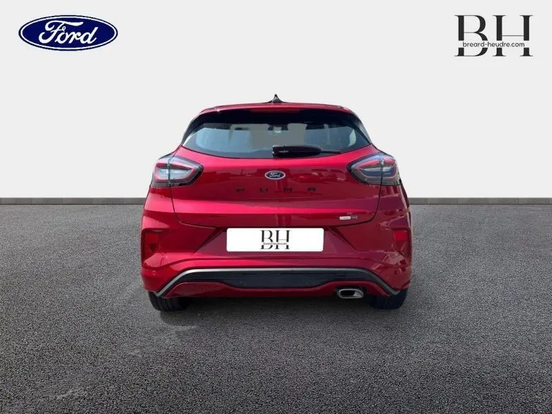 Vue arrière d'une Ford Puma 1.0 EcoBoost 125ch mHEV ST-Line rouge métallisé avec échappement chromé et feux LED.