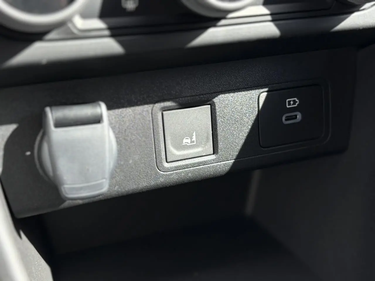Gros plan sur la console centrale du Dacia Jogger 2025, montrant prises USB et bouton d'aide au maintien en voie.