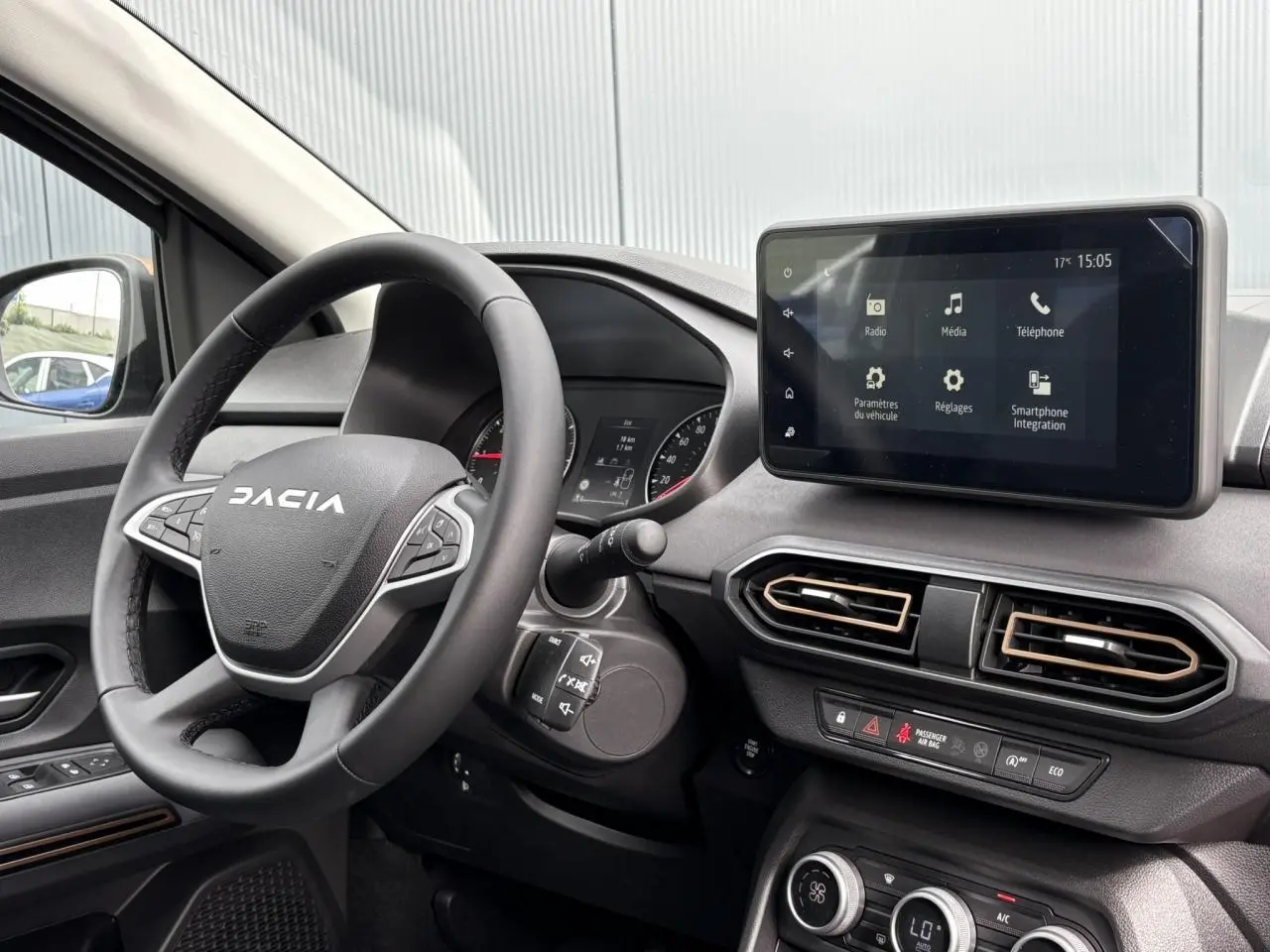 Intérieur du Dacia Jogger 2025 vu côté gauche, volant noir, écran tactile central et aérateurs hexagonaux.