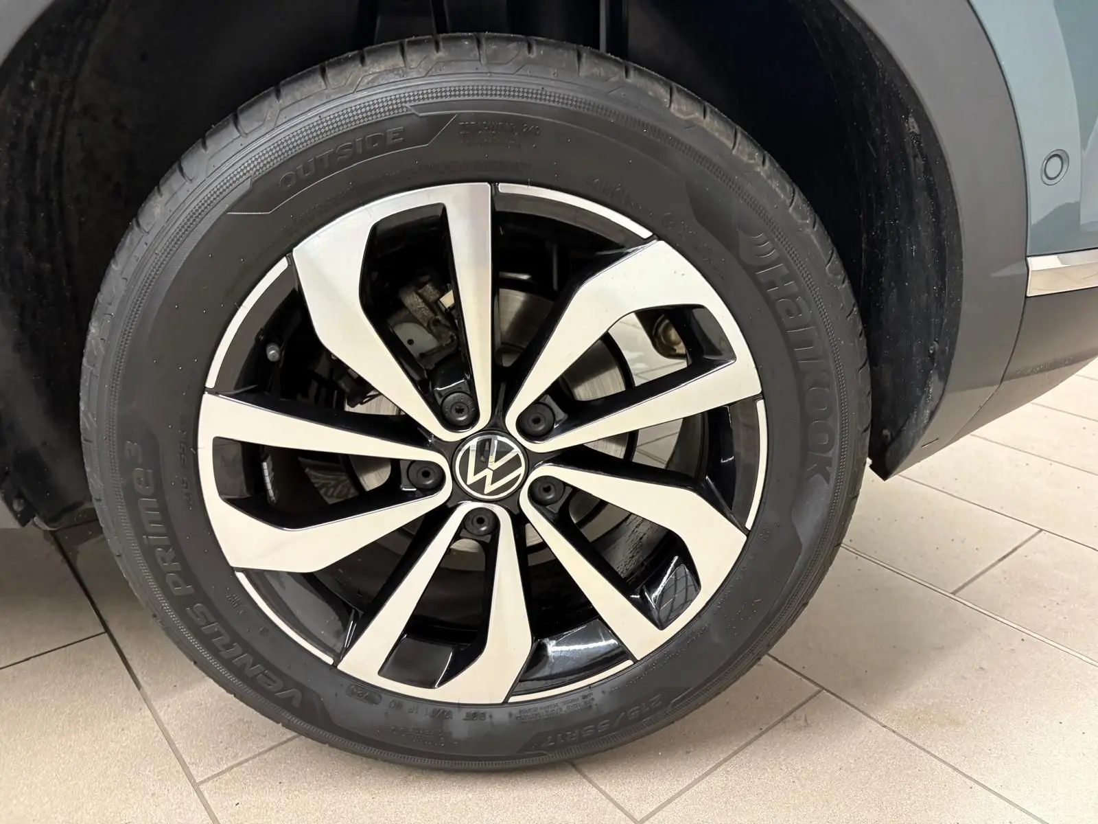 Gros plan sur la jante alliage bicolore du côté avant droit du Volkswagen T-Roc bleu pétrole 2025.