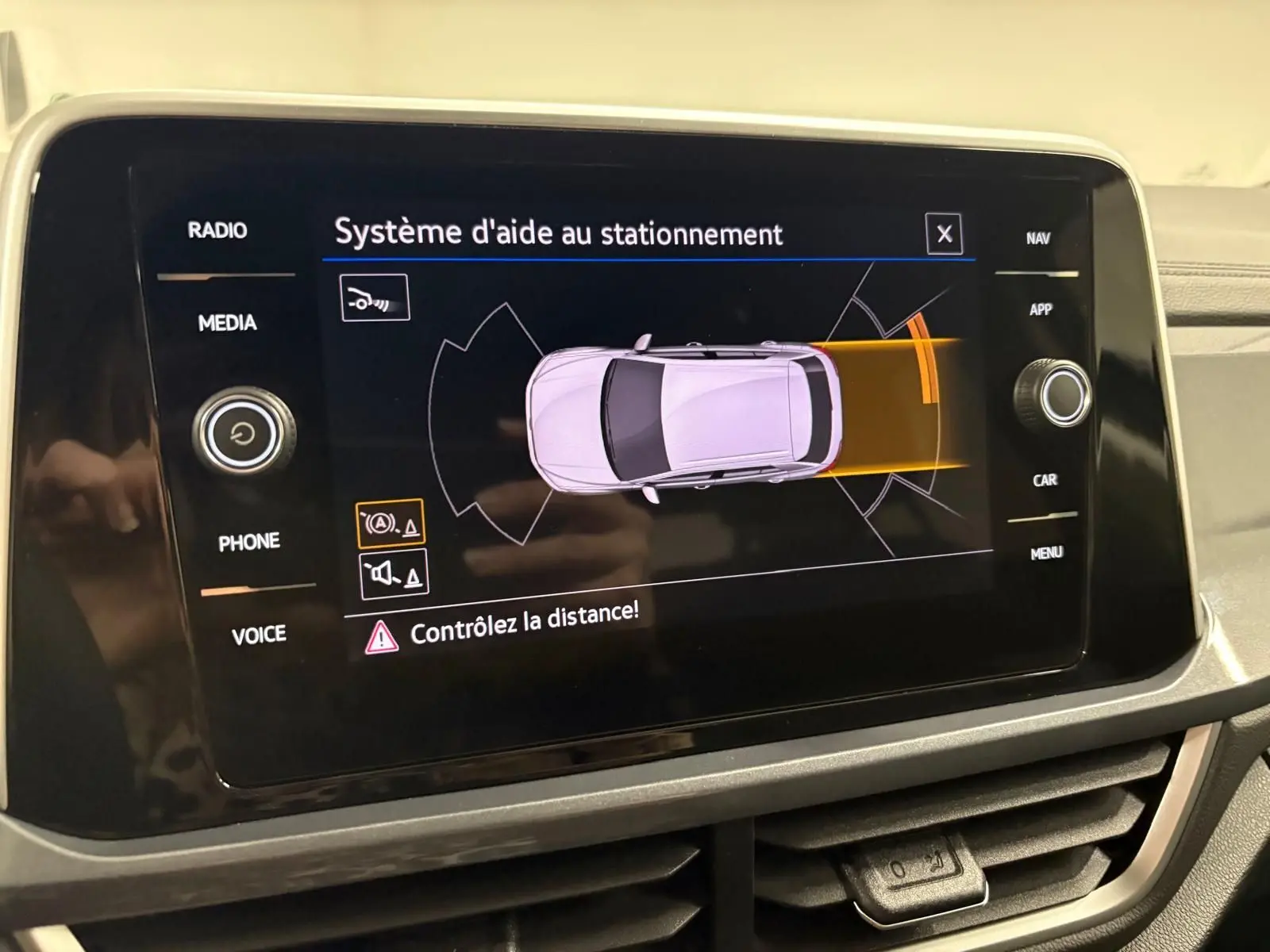 Écran tactile du système d'aide au stationnement du Volkswagen T-Roc 2025 affichant l'alerte de distance.