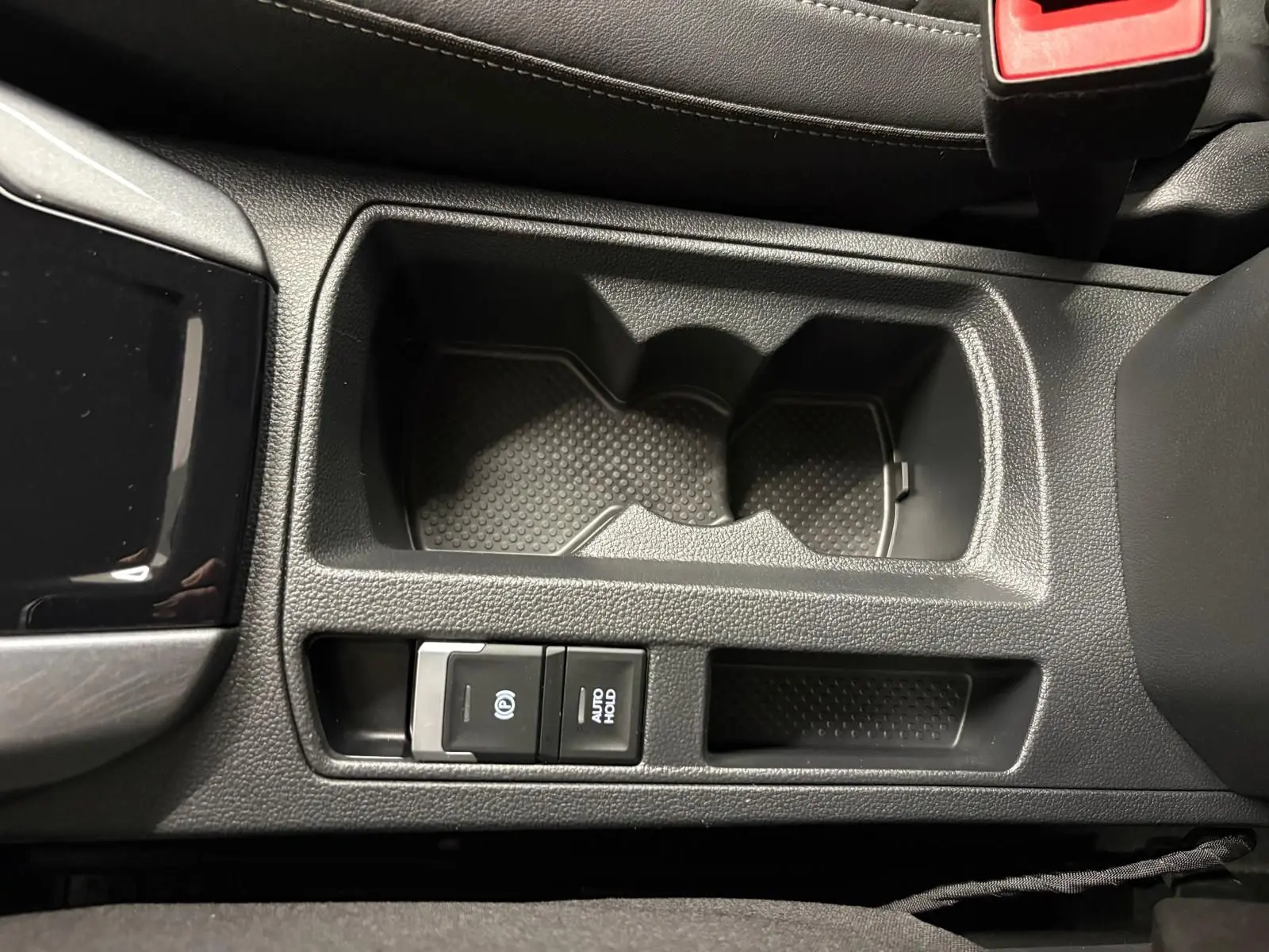 Gros plan sur la console centrale du Volkswagen T-Roc 1.5 TSI 150 DSG7 Style Edition avec porte-gobelets et commandes électroniques.