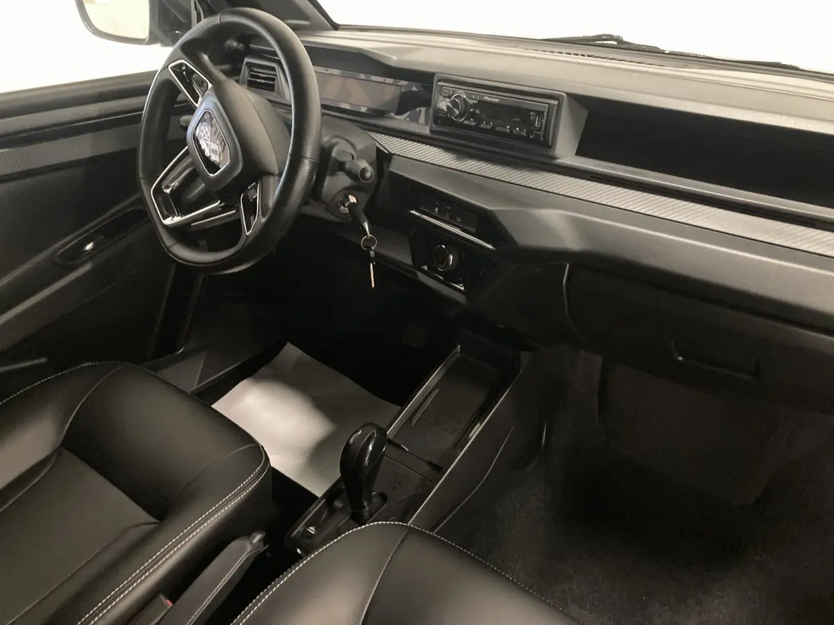 Vue intérieure côté conducteur de la Ligier JS50 0.5 REVO D+ SELECT 2026 noire, avec volant, autoradio Pioneer et boîte auto.