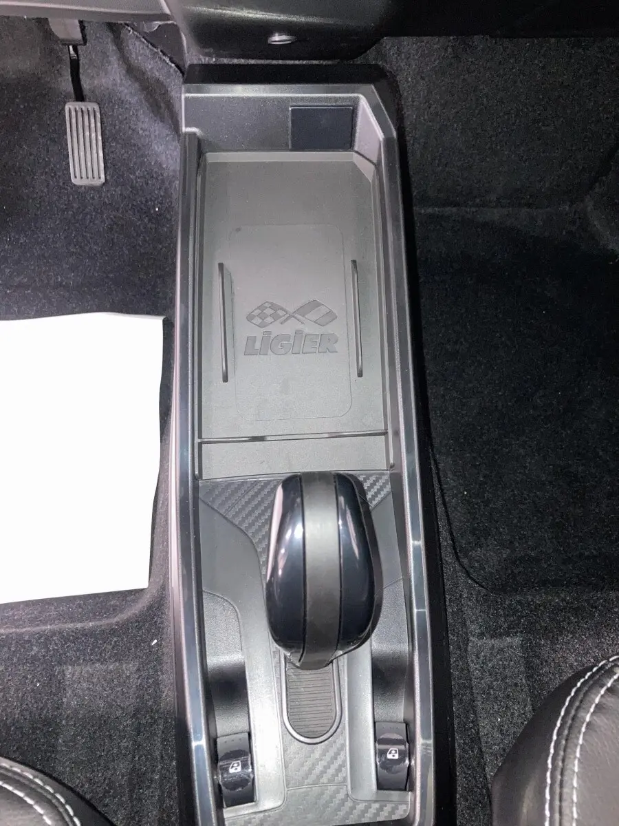 Vue plongeante sur la console centrale noire du Ligier JS50 2026 avec levier de boîte auto et logo Ligier visible.