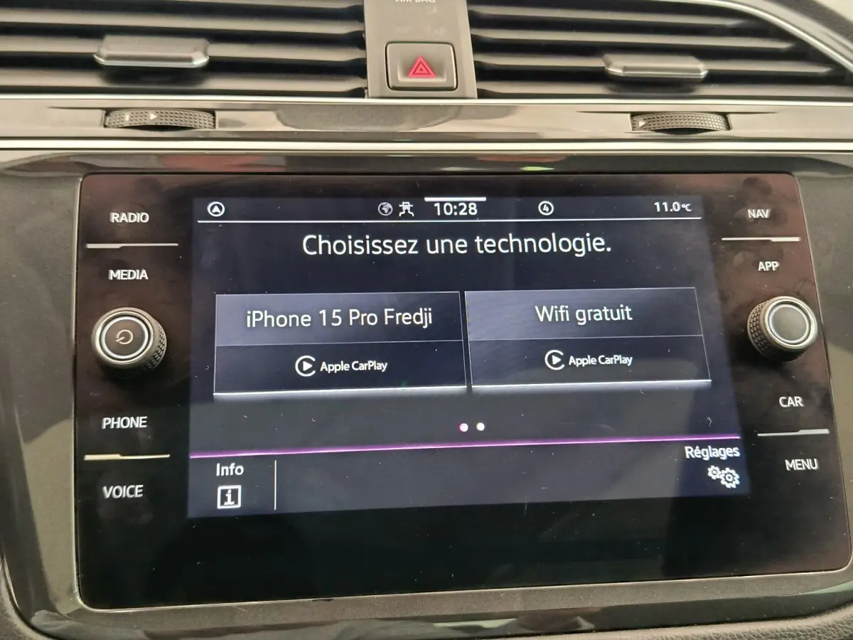 Écran tactile central du tableau de bord du Volkswagen Tiguan 2022 affichant options Apple CarPlay et WiFi gratuit.