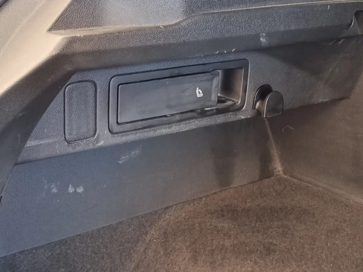 Détail du coffre noir du Volkswagen Tiguan 2.0 TDI 150 DSG7 Elegance avec levier de siège rabattable intégré.