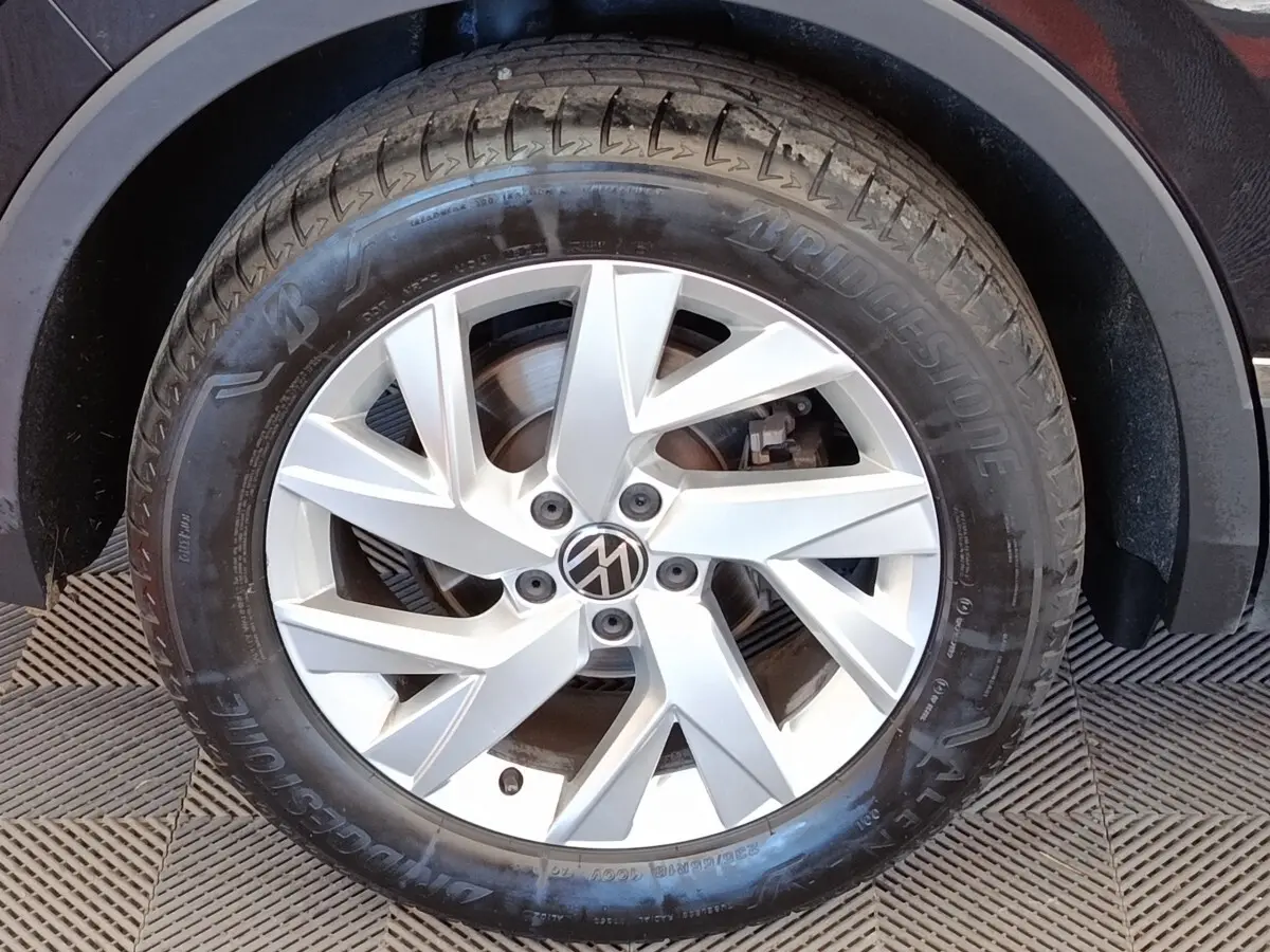 Gros plan sur la roue avant droite d’un Volkswagen Tiguan noir, avec jante alliage argentée et pneu Bridgestone.