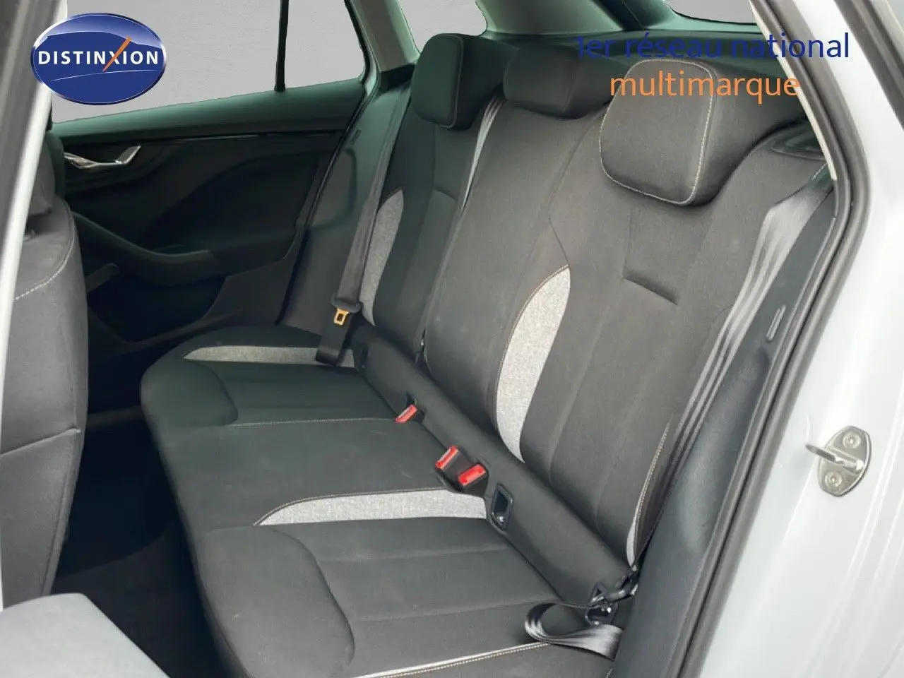 Vue intérieure côté droit des sièges arrière du Skoda Kamiq blanc glacier avec sellerie tissu noir et inserts gris.