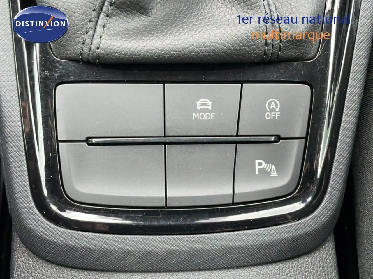 Gros plan sur les boutons de commande de mode de conduite et assistance au stationnement dans une Skoda Kamiq 2025.