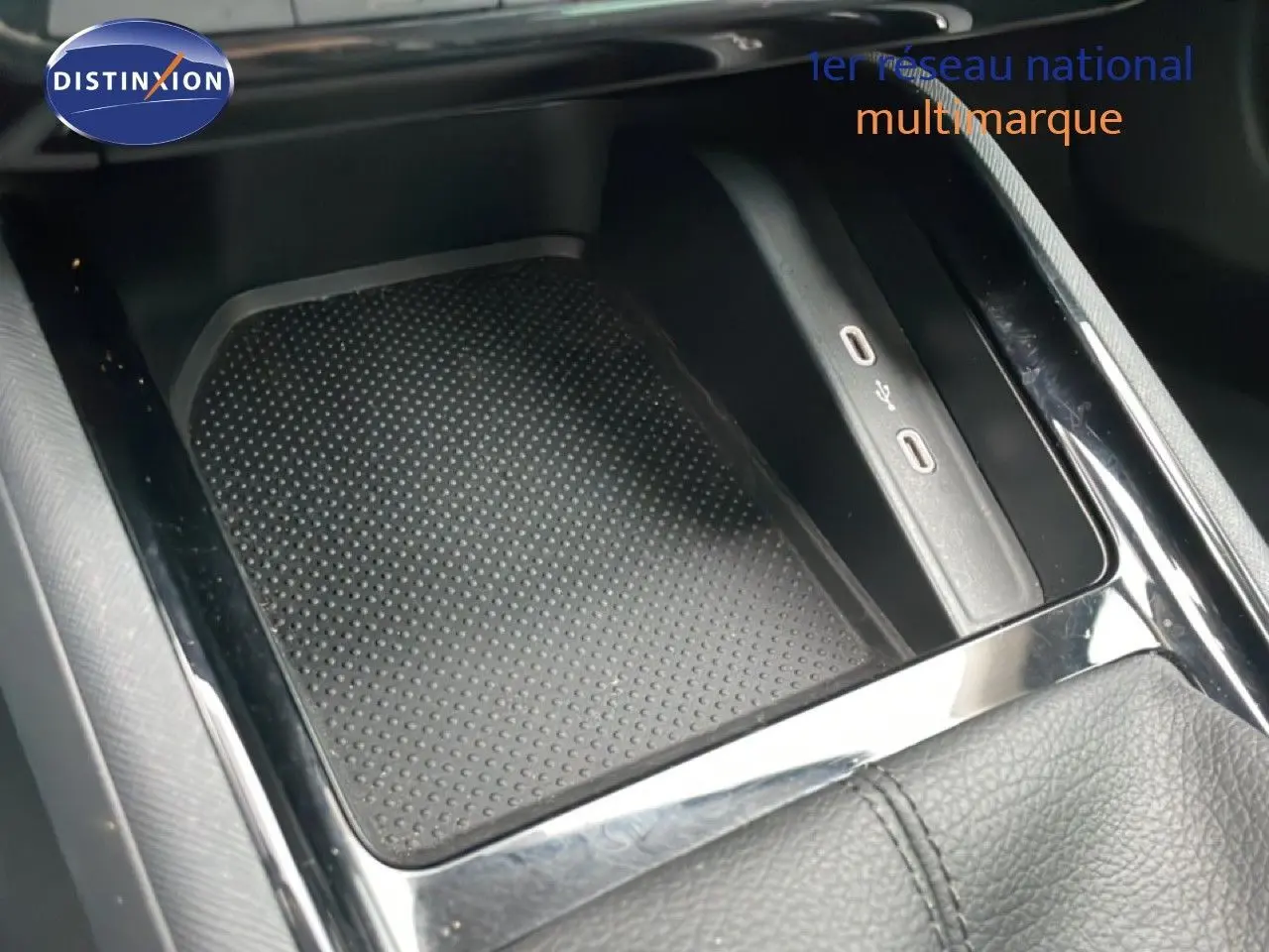 Gros plan sur la console centrale noire du Skoda Kamiq 2025, montrant un espace de rangement avec ports USB intégrés.