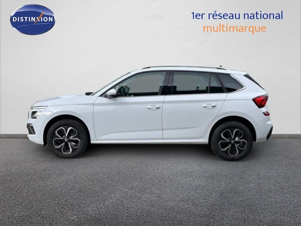 Vue de profil côté gauche d'un Skoda Kamiq blanc glacier 2025 avec jantes noires et toit panoramique.