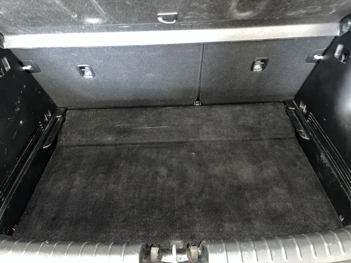 Coffre spacieux et propre du Kia Stonic blanc 2019, avec double plancher et revêtement noir.