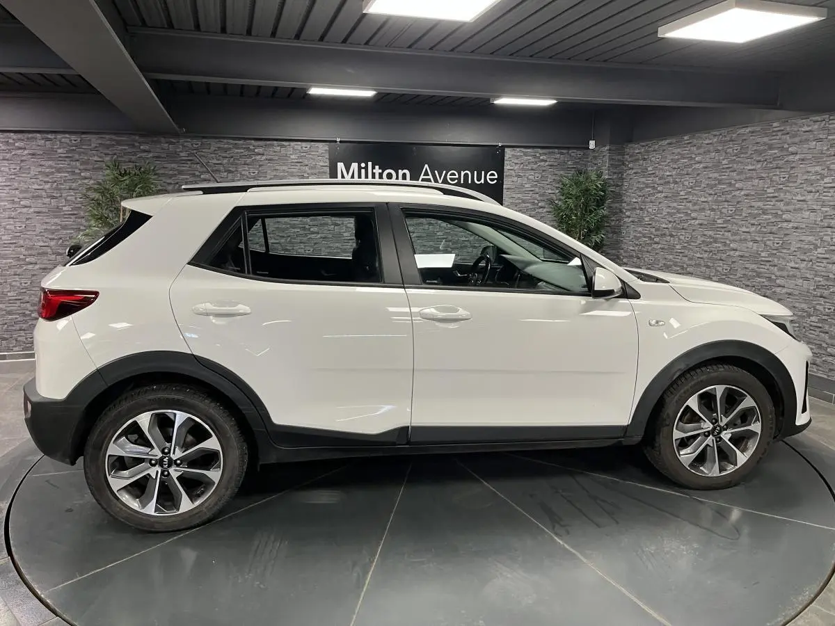 Profil droit du KIA STONIC blanc 2019 avec jantes alliage 17 pouces et protections noires sur les passages de roues.