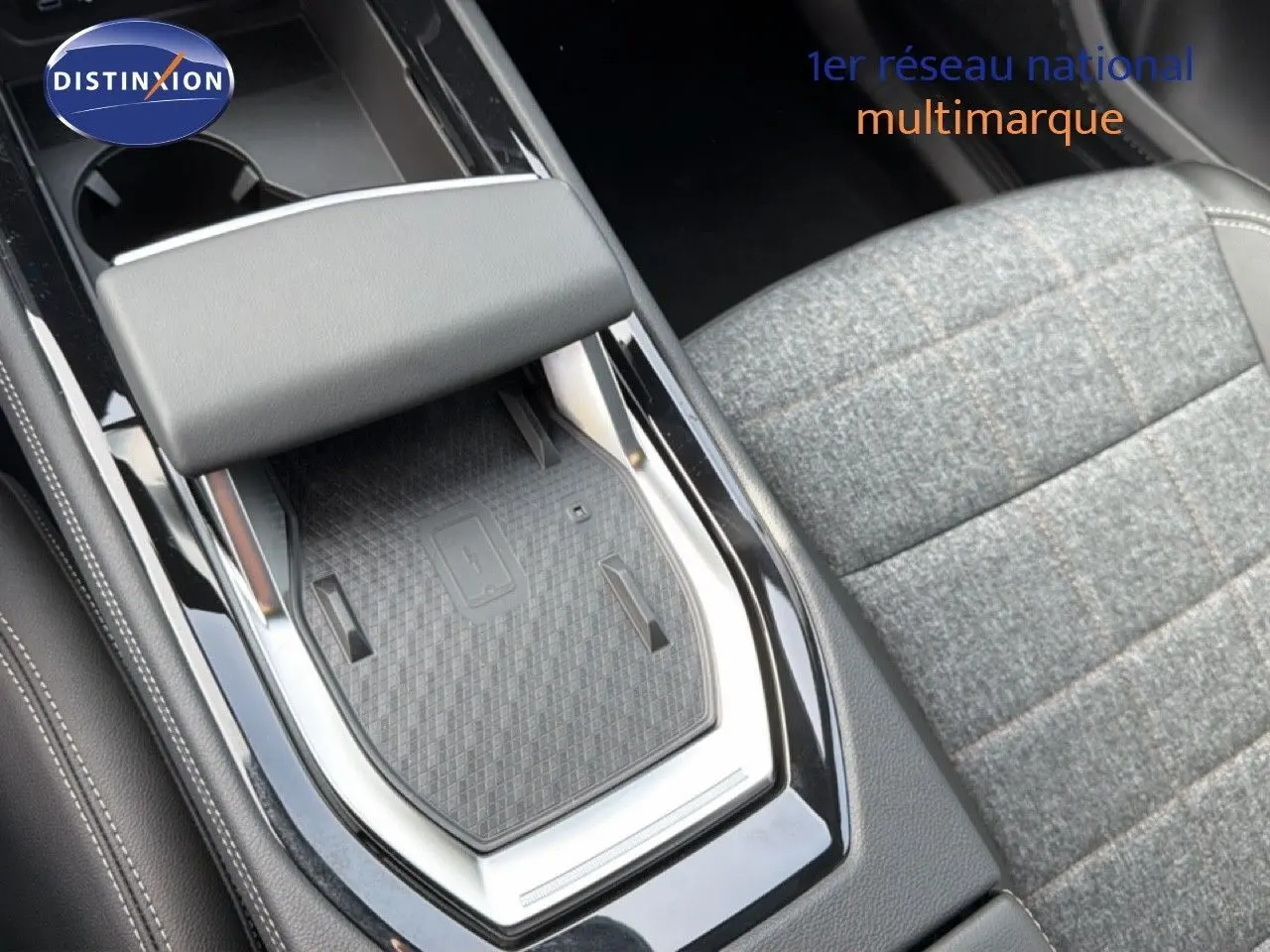 Gros plan sur la console centrale noire et le siège tissu gris à motifs du Renault Espace 2025 hybride.