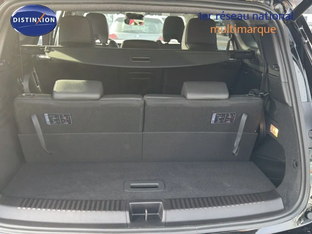 Coffre ouvert d'un Renault Espace 2025 noir étoile métal, montrant la banquette arrière et le cache-bagages.