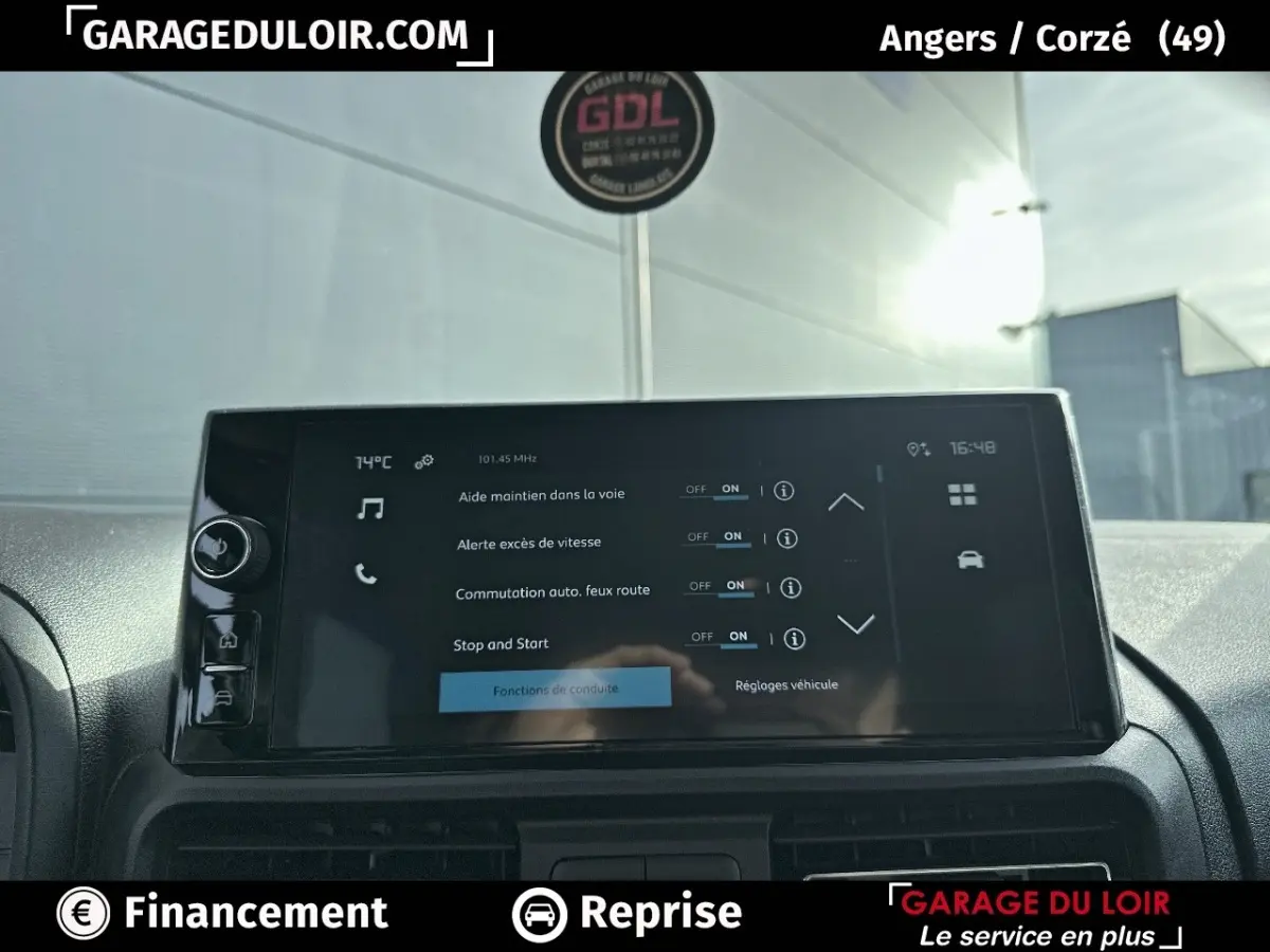 Écran tactile central du tableau de bord du Citroën Berlingo gris clair, affichant les aides à la conduite.