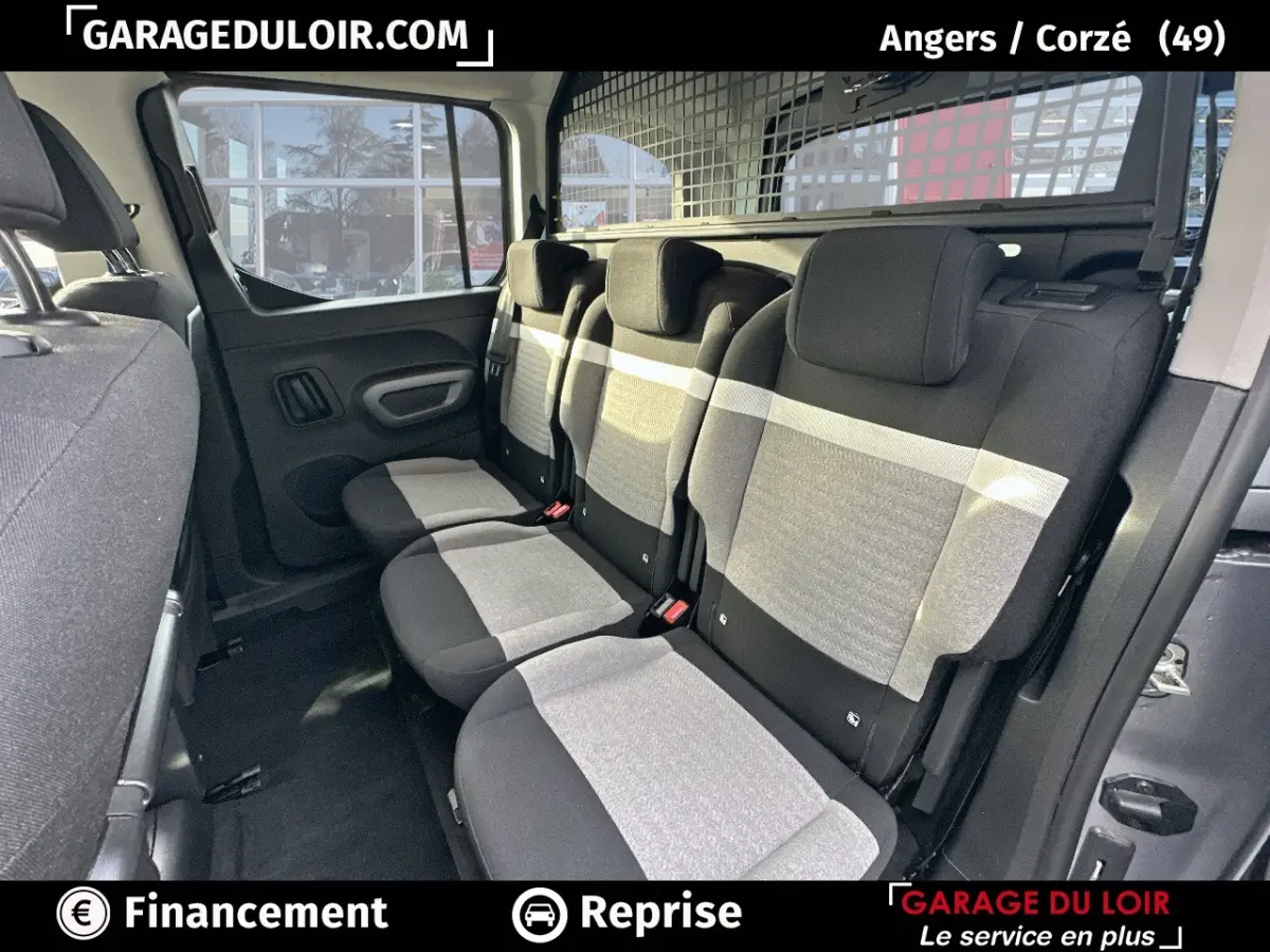 Vue intérieure côté droit sur la banquette arrière grise et noire du Citroën Berlingo 2024 avec grille de séparation.