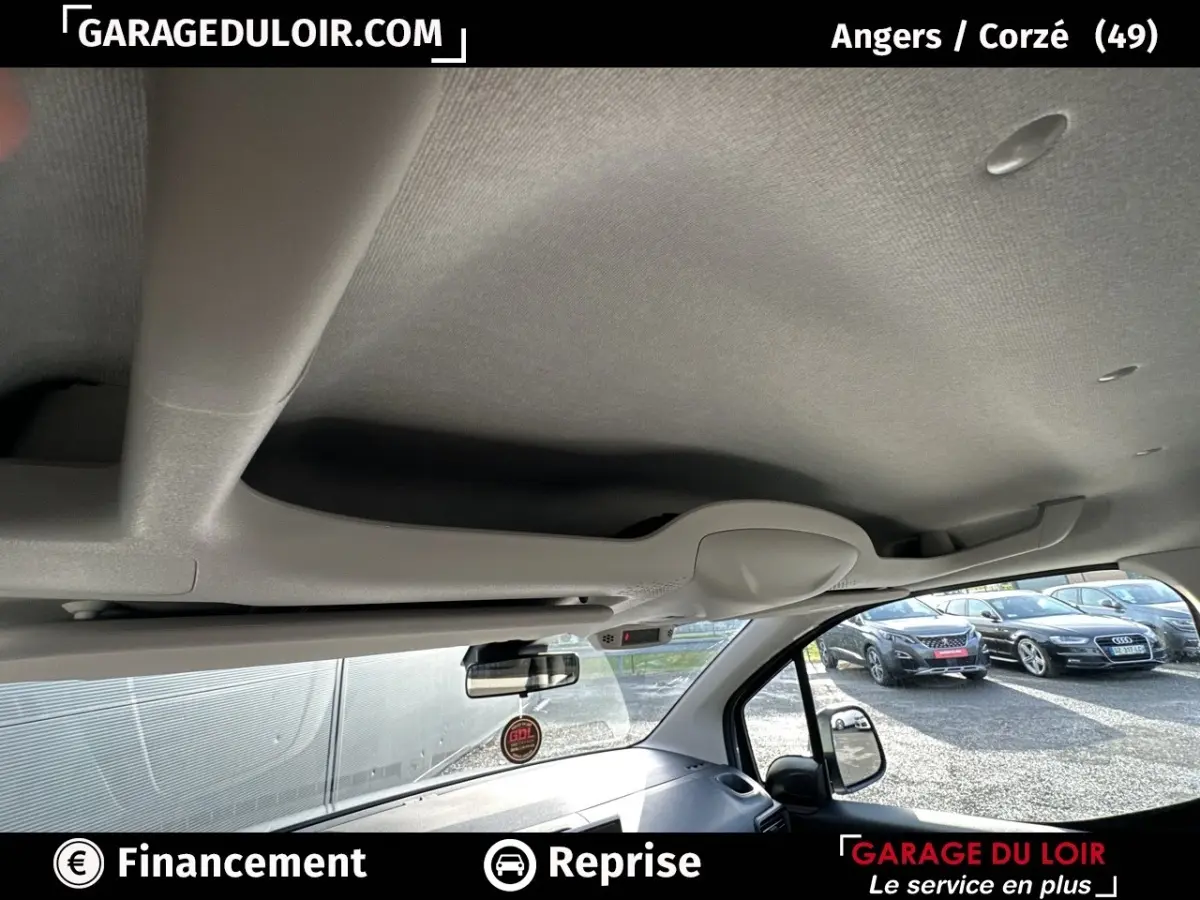 Vue intérieure du plafond et pare-brise côté droit du Citroën Berlingo gris clair 2024 avec rétroviseur et tableau de bord partiel visible.