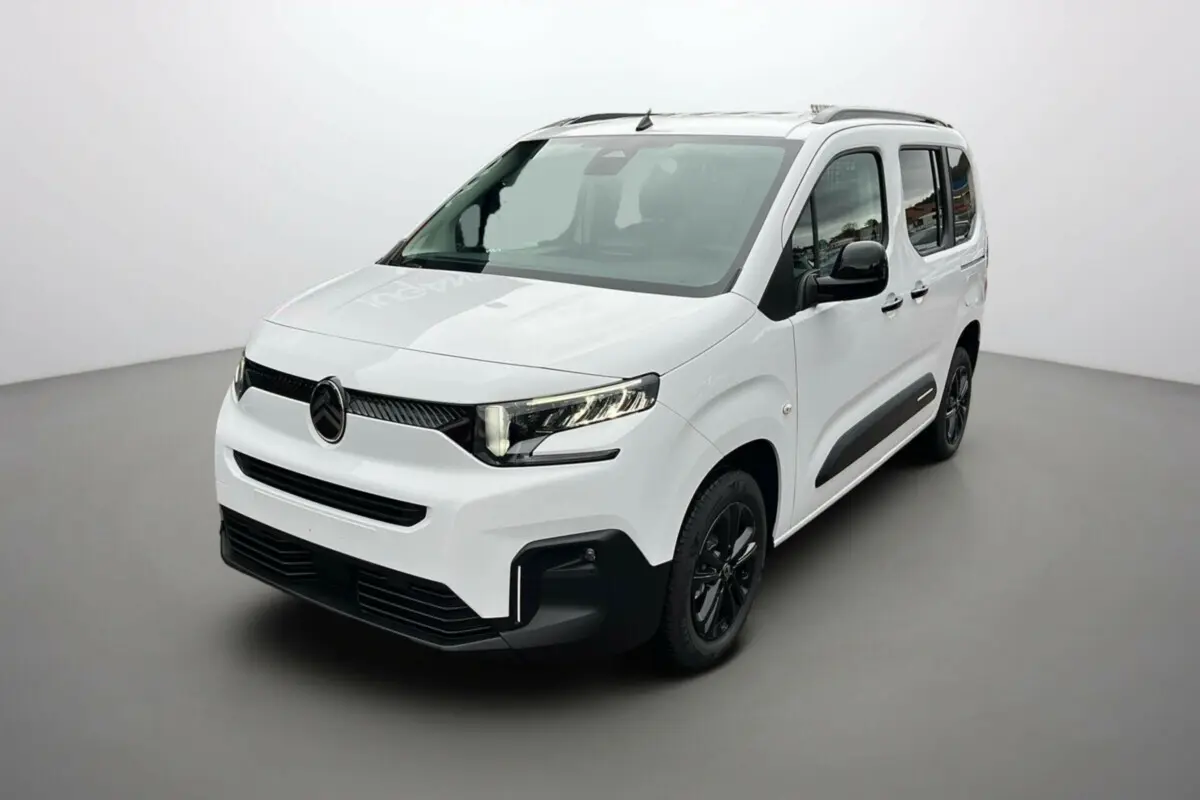 Vue 3/4 avant du Citroën Berlingo Kaolin white avec jantes noires et barres de toit visibles.