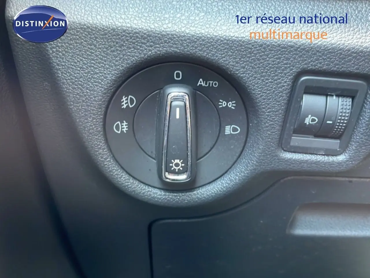 Gros plan sur la molette de réglage des phares du Skoda Kamiq 2025, tableau de bord noir texturé.