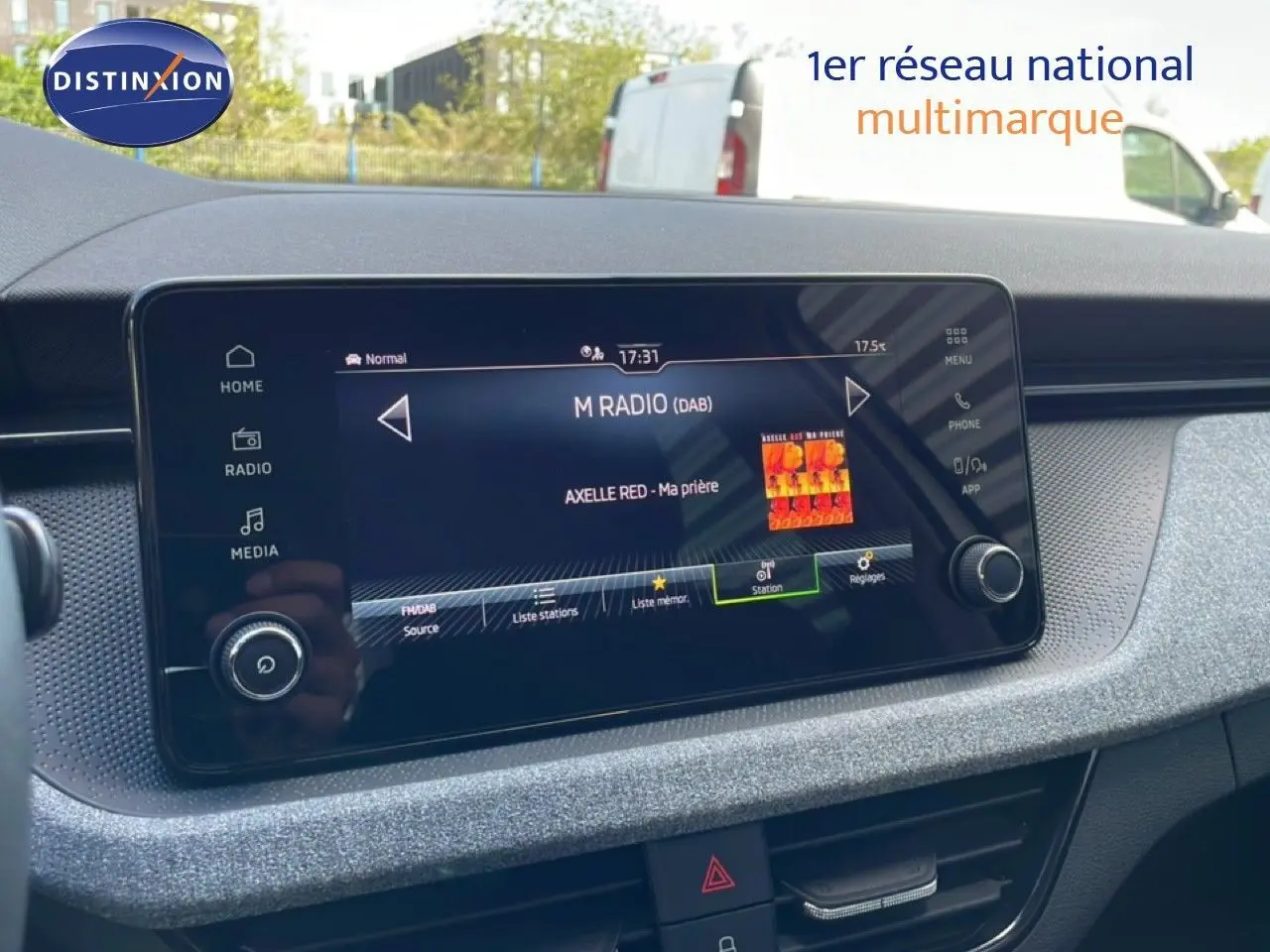 Vue rapprochée de l’écran tactile central du Skoda Kamiq 2025 gris argent, affichant la radio numérique avec la chanson en cours.
