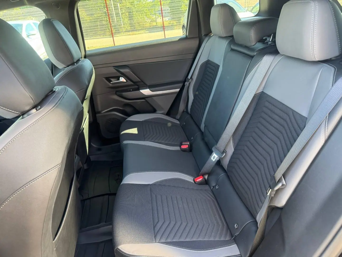 Vue intérieure de la banquette arrière noire et grise du Jeep Compass 2026, avec ceintures de sécurité visibles.