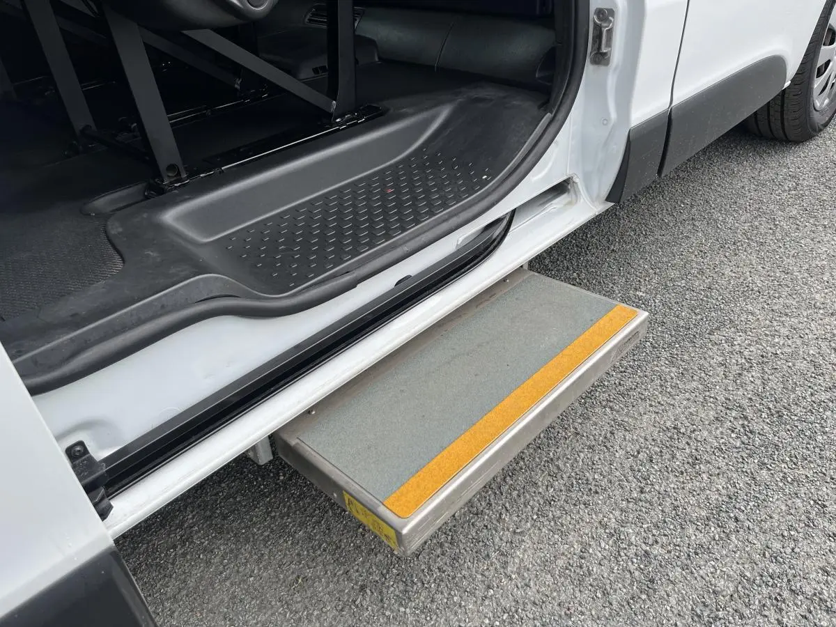 Marche-pied déployé côté gauche du Renault Trafic blanc, avec seuil d'entrée et intérieur noir visible.